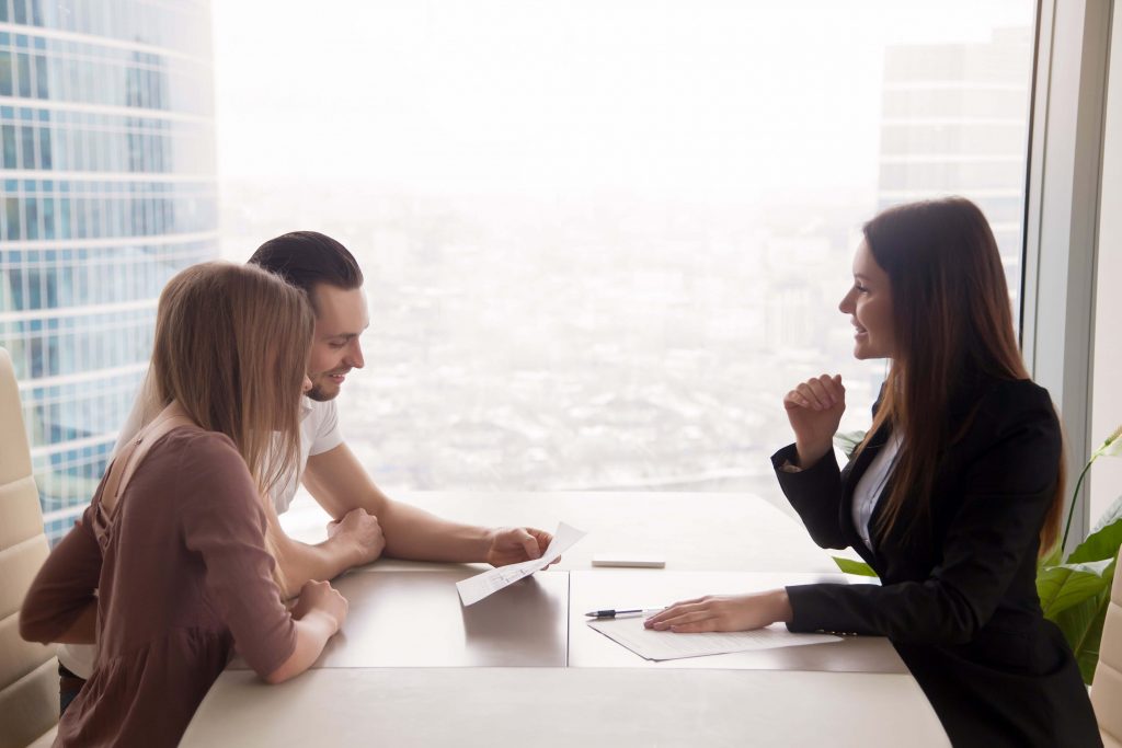 couple signing documents with property conveyancing solicitor